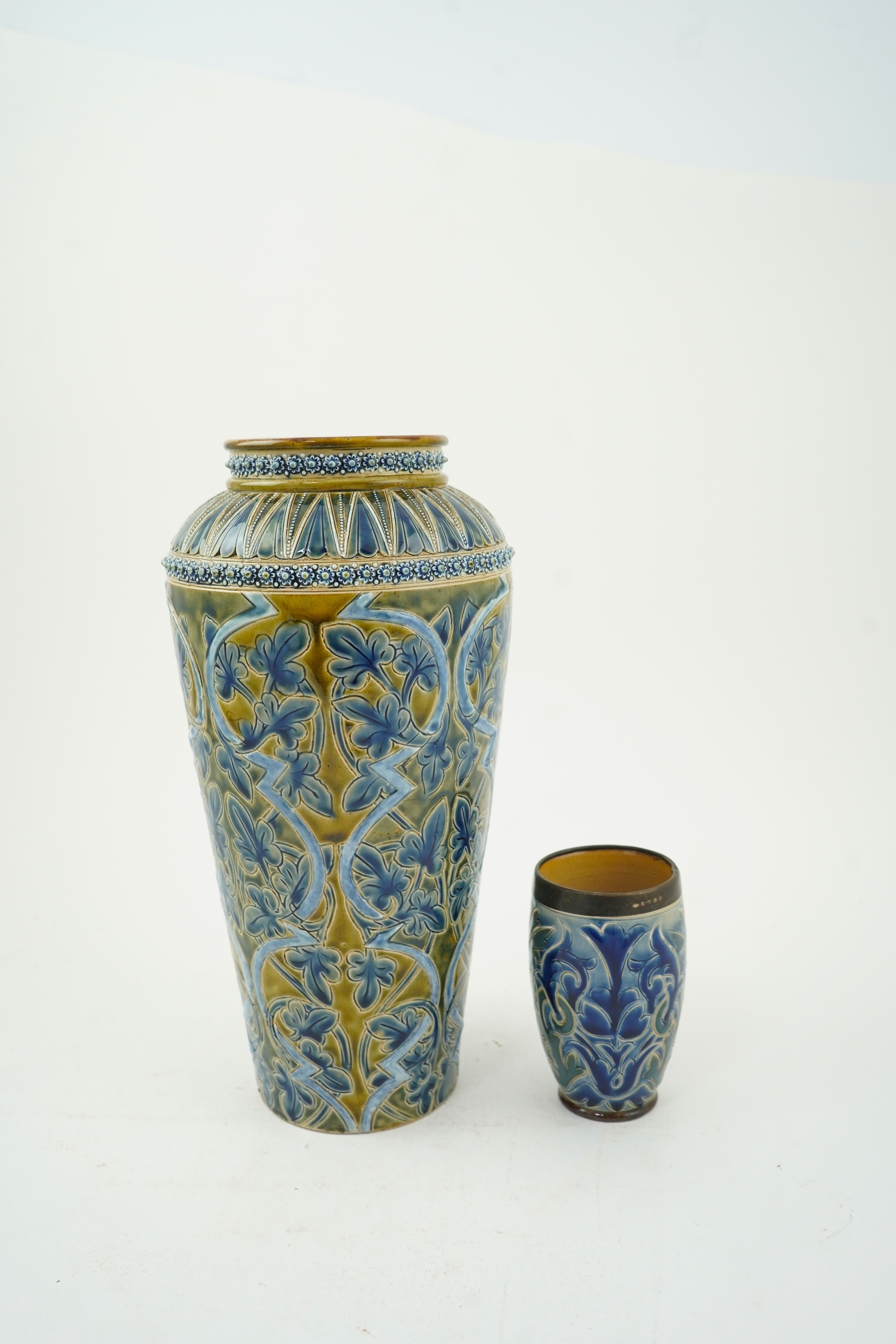 A Doulton Edith Lupton stoneware vase, drill hole to base, together with a similar Martha Rogers silver mounted cup, Tallest 31cm